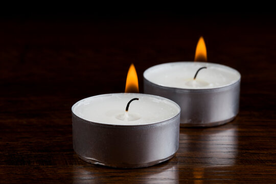 burning tealight candle pair in the dark closer