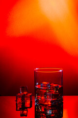 Single malt whiskey with ice on red