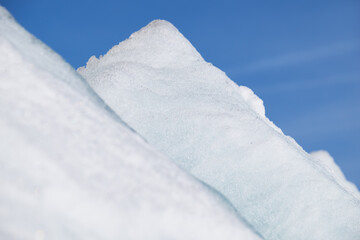 Fototapeta na wymiar Ice pyramids on blue sky background.
