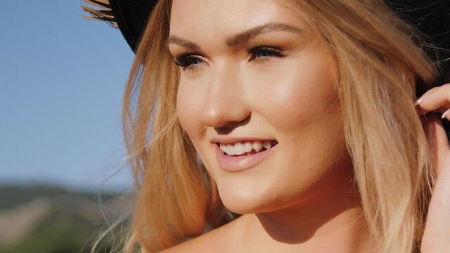 Blonde beautiful woman in boho style and Bowler Hat walking on a sunny day - Close up