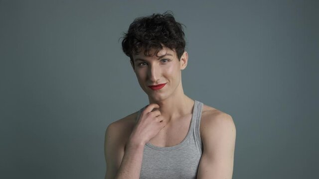 Portrait of handsome androgynous man with makeup sending air kiss to camera. Medium shot. Masculine and feminine characteristics in one person. Gender identity concept 4k
