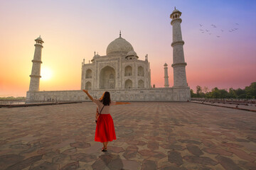 Taj Mahal Agra iconic monument on the banks of river Yamuna at sunrise with female tourist enjoying the view
