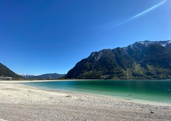 Fototapeta na wymiar Achensee zwischen Maurach und Pertisau im Karwendel Tirol Österreich in der Nähe von Achenkirch Schwaz Jenbach Stans - Niedrigwasser Ebbe Schilf im Frühjahr 
