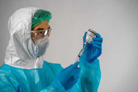 Asian medical scientist man in PPE suit protection with virus pandemic vaccine in hands on white background copy space. healthcare and medicine concept. 