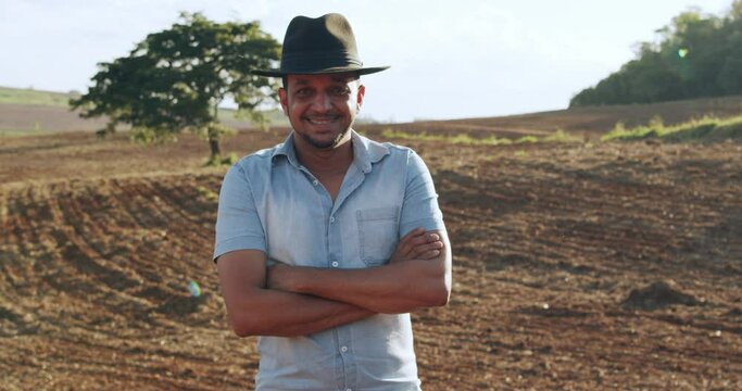 Brazilian farmer man stand at the green farm with happy and smile. Latin farmer. 4K.
