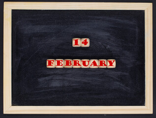 Message 14 February spelled in wooden blocks on a black background