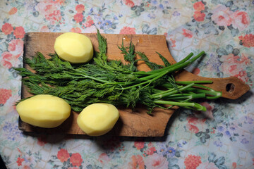 Green dill and peeled uncooked potatoes