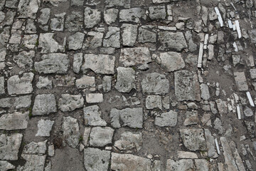 The road is paved with stones. Background texture of old stones - 402869969