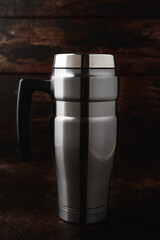Travel Tumbler hot or cold drinks mug cup Stainless Steel Insulated Flask on wooden background