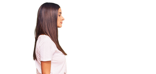 Young hispanic woman wearing casual white tshirt looking to side, relax profile pose with natural...