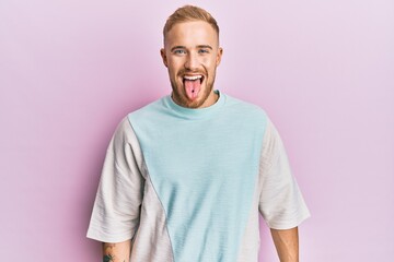 Young caucasian man wearing casual clothes sticking tongue out happy with funny expression. emotion concept.