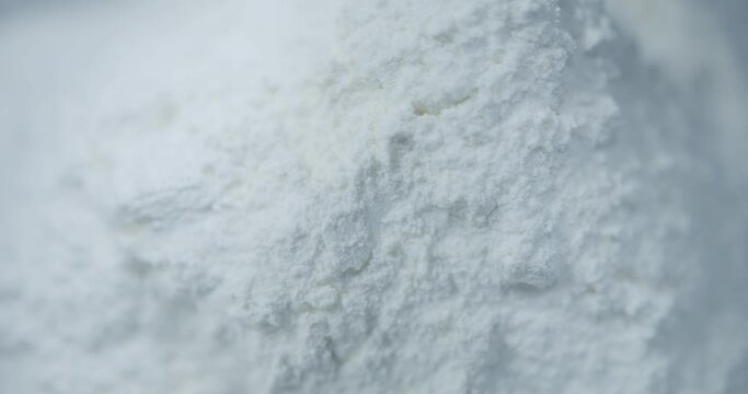 Macro close up detail of white powder flour pouring falling down