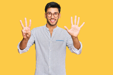 Young handsome man wearing casual clothes and glasses showing and pointing up with fingers number eight while smiling confident and happy.
