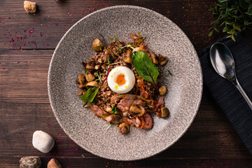 plate with buckwheat porridge, fried bacon and eggs. rich dish for the meal buckwheat porridge with egg and bacon, healthy breakfast