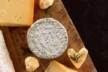 Goat blue cheese closeup on a board with other cheeses top view selective focus.