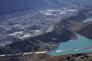 View on Gokyo and ngozumpa glacier (longest Himalayan glacier) from Gokyo Ri Peak with prayer flags in the foreground