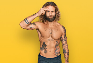 Naklejka premium Handsome man with beard and long hair standing shirtless showing tattoos worried and stressed about a problem with hand on forehead, nervous and anxious for crisis