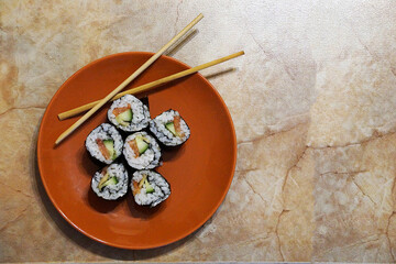 Japanese sushi and wooden sticks on a plate