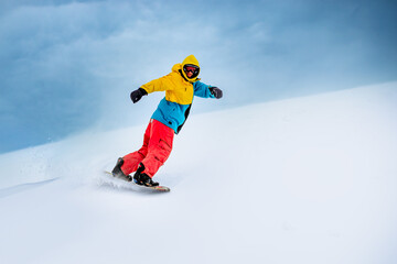 Fototapeta na wymiar Snowboarder Riding Snowboard in the Mountains. Snowboarding and Winter Sports