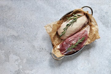 Uncooked duck breast with herbs and spices . Overhead view. Copy space