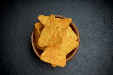 Yummy potato chips on black background
