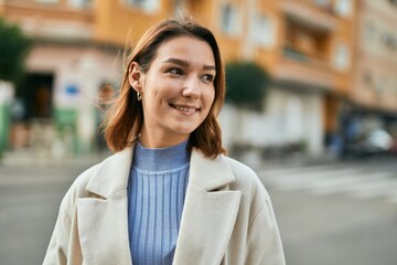 Young hispanic woman smiling happy standing at the city