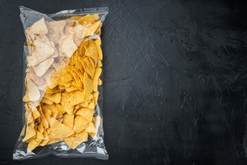 Packed and seasoned nachos and snack, on black background, top view or flat lay with copy space for...