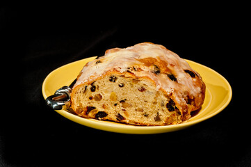 top, front view, medium, close distance of a Christmas stollen loaf soon a round gold plate with black background