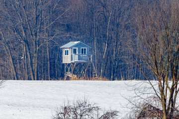 Homemade elevated hunting blind during winter with snow. Selective focus, background blur and...