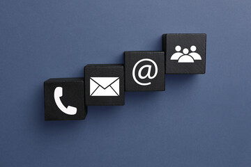 Hotline service. Black cubes with icons on dark background, flat lay