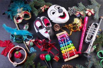Carnival masks, musical instruments and Christmas decorations on a black background.