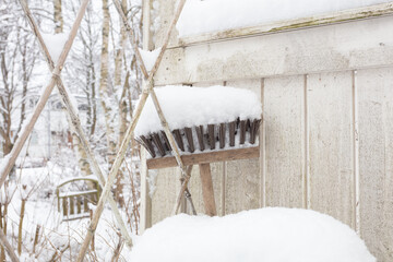 mop in the snow by a wooden fence for outdoor cleaning, upside down