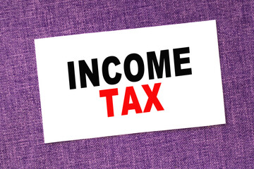 On the sheet for notes the text INCOME TAX The concept of world business, marketing, finance.
