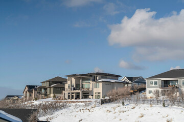 Fototapeta na wymiar Luxury houses on a scenic mountain neighborhood blanketed with snow in winter
