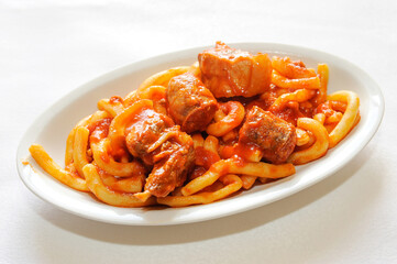 homemade macaroni with black nebrodi pork sauce in Sicily Nebrodi mountain isolated on white background