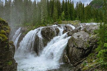 Rjukandefoss waterfall with dust and a rock