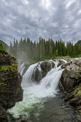 Rjukandefoss waterfall with dust and a rock