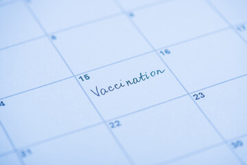Vaccination concept. Close up view photo of word vaccination written on calendar cell