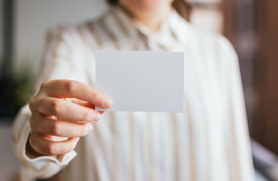 Blank business card mockup closeup held by a businesswoman. Branding design template concept