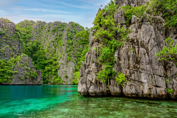 Obraz na płótnie Canvas Blue crystal water in paradise Bay with boats on the wooden pier at Kayangan Lake in Coron island, tropical travel destination - Palawan, Philippines.