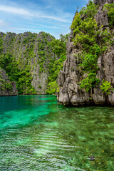 Plakat Blue crystal water in paradise Bay with boats on the wooden pier at Kayangan Lake in Coron island, tropical travel destination - Palawan, Philippines.