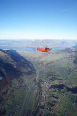 Wingsuit flier glides over snowcapped mountains