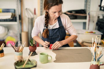 Mature woman working with clay - Art work studio handmade handcraft ceramic pottery