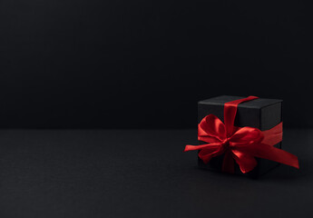 Black gift boxes with red ribbon on black background with copy space for text. The Concept Of...
