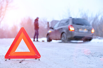 car repair on the road in winter. Car triangle on winter road. Problem with vehicle on snowy road. Broken cars concept. banner of snowy winter road.