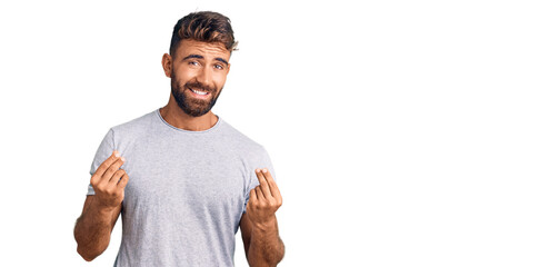 Young hispanic man wearing casual clothes doing money gesture with hands, asking for salary...