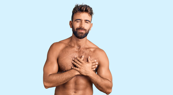 Young hispanic man wearing swimwear shirtless smiling with hands on chest with closed eyes and grateful gesture on face. health concept.