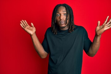 African american man with braids wearing casual clothes clueless and confused with open arms, no idea and doubtful face.