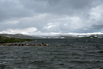Lake with mountains and green land around it