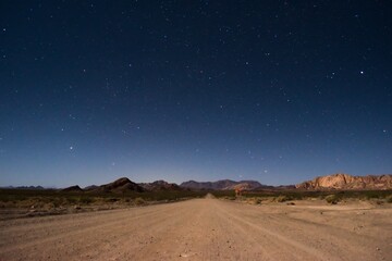 Starry night sky above a dirt road across the desert near Uspallata, Mendoza, Argentina.